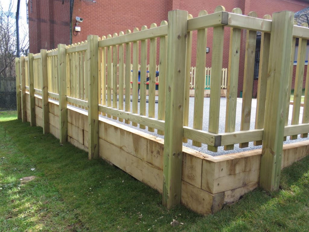 Wooden picket fencing surrounding a childrens play space
