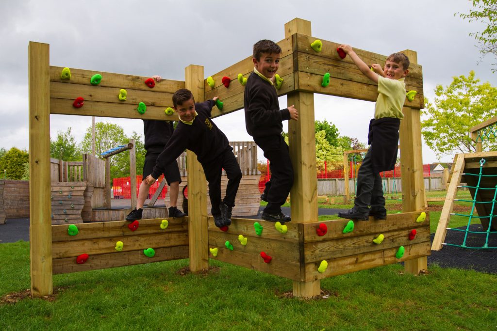 Children playing on the forest traverse play equipment