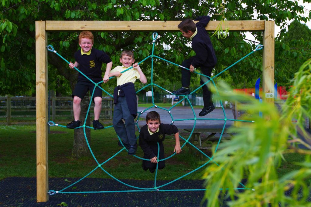 A cobweb walk rope climber with four children playing