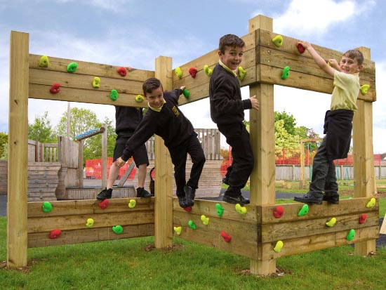 Young boys playing on a wooden zig zag climbing frame