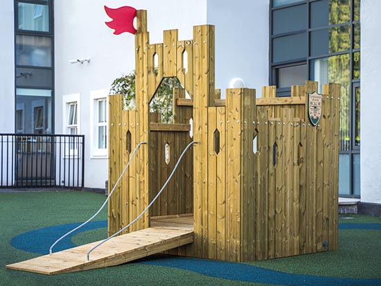 A wooden play castle in a play area