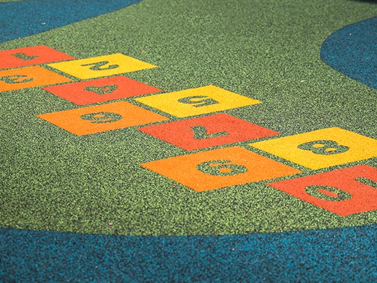 A play area with orange and yellow safety surfacing