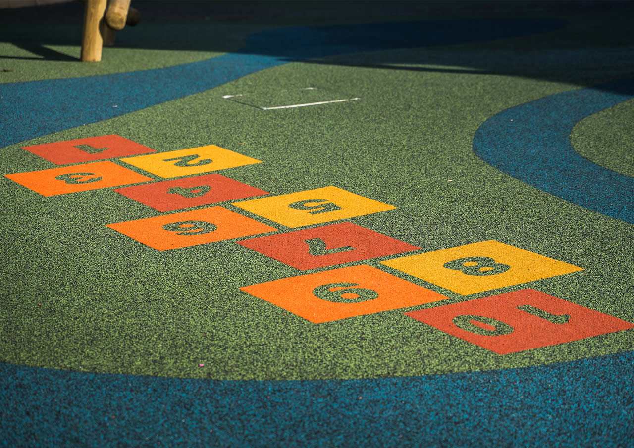 Colourful wet pour safety surfacing installed in a play area