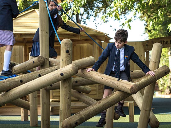Wooden play pole climbers in use