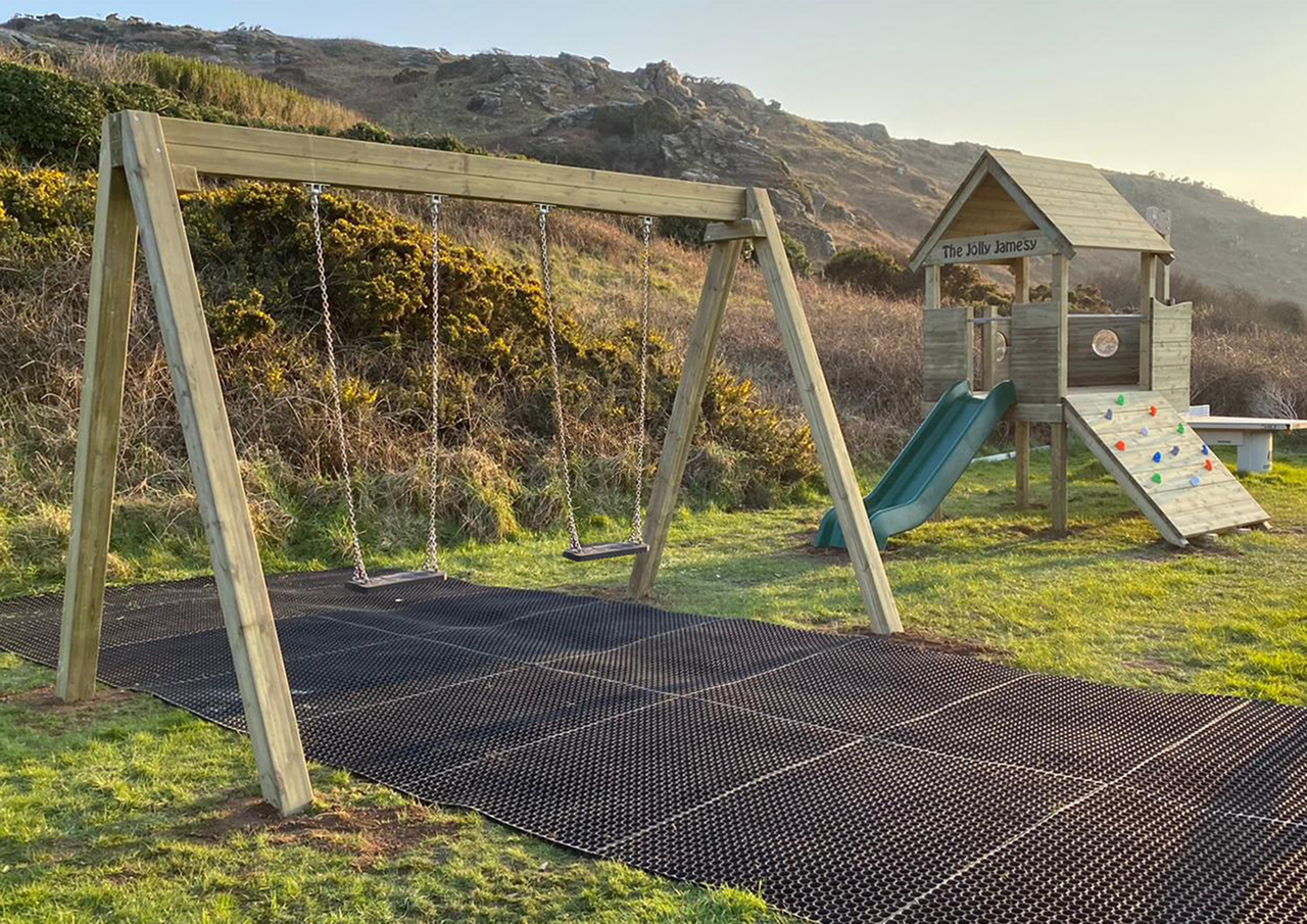Play area double bay swings over safety flooring