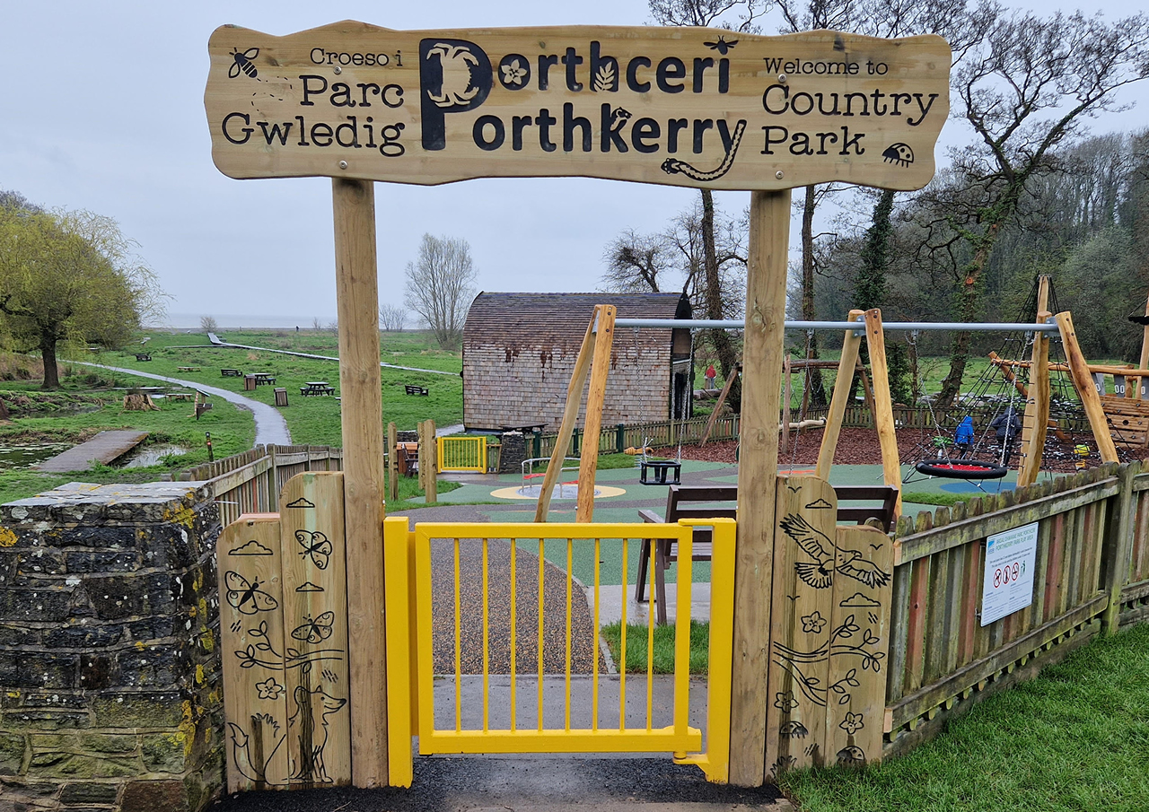 A wooden engraved archway at the entrance to a play area