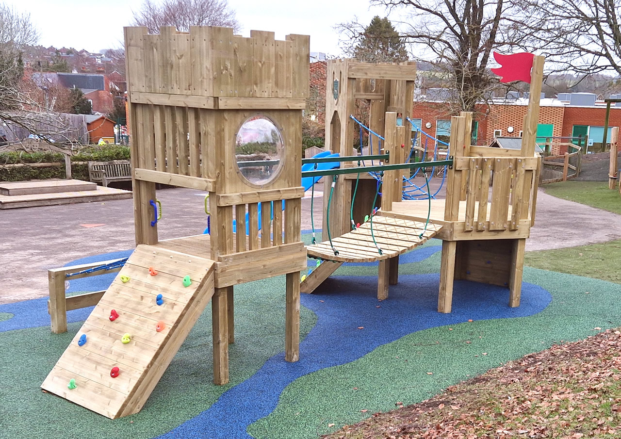 Wooden play towers linked with bridges installed in a playground